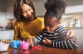 Mother watching child use craft beads