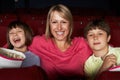 Mother Watching Film In Cinema With Two Children Royalty Free Stock Photo