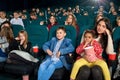 Mother watching movie with children in the cinema.