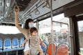 a mother wears a mask and carries her child while standing on the bus Royalty Free Stock Photo