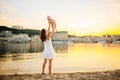 Mother which turns the child against a sunset and water. Happy mom and baby. Playing on beach. Young woman tossing up her son Royalty Free Stock Photo