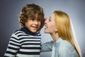 Mother whispering to son close up on gray background Royalty Free Stock Photo