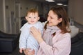 A mother woman holds a happy toddler baby boy in her arms in the lob Royalty Free Stock Photo