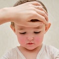 A mother woman measures the temperature of a ill toddler baby with h Royalty Free Stock Photo