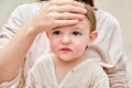 A mother woman measures the temperature of a ill toddler baby with h Royalty Free Stock Photo