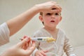 A mother woman measures the temperature of a sick toddler baby wit Royalty Free Stock Photo