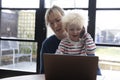 A mother working from home at a laptop computer with her young son on her lap Royalty Free Stock Photo