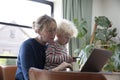 A mother working from home at a laptop computer with her young son on her lap Royalty Free Stock Photo