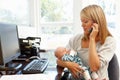 Mother working in home office with baby Royalty Free Stock Photo