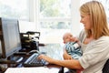 Mother working in home office with baby Royalty Free Stock Photo