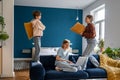 Mother working on laptop while her active noisy children playing with pillows and having fun Royalty Free Stock Photo