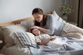 Mother worried son health check hot forehead lying on bed pillow. Preschooler feeling head pain ache Royalty Free Stock Photo