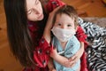 A mother worries about her sick child. Portrait of a young child measuring temperature. masked child Royalty Free Stock Photo