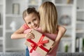 Mother& x27;s Day. Cute Little Girl Holding Gift Box And Embracing Her Mommy Royalty Free Stock Photo