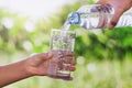 mother& x27;s hand pouring drinking water into glass form bottle give Royalty Free Stock Photo