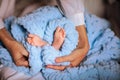 Mother& x27;s hands holding newborn& x27;s feet near soft blue blanket. Royalty Free Stock Photo