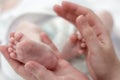 The mother& x27;s hands tenderly and lovingly hold the legs of a small child who is several months old from the moment of Royalty Free Stock Photo