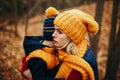 Mother in yellow hat scarf hugging pacifying sad upset crying toddler boy son in autumn fall park outdoor. Royalty Free Stock Photo