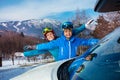 Mother, young boy waving hands stand near car at ski destination Royalty Free Stock Photo