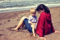 Mother and young daughter sitting on the beach Royalty Free Stock Photo