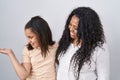 Mother and young daughter standing over white background smiling showing both hands open palms, presenting and advertising Royalty Free Stock Photo