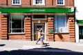 Mother And Young Daughter Walking Past A Branch Of Lloyds Bank