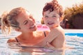 Mother With Young Son Having Fun On Summer Vacation Splashing In Outdoor Swimming Pool Royalty Free Stock Photo