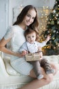 Mother and young son at home near Christmas tree Royalty Free Stock Photo