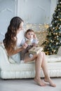 Mother and young son at home near Christmas tree Royalty Free Stock Photo