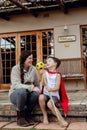 A mother and young son sitting on their porch in front of their new home. Royalty Free Stock Photo