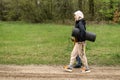 A mother and a young son walk in the park. A woman with a tourist mat and a boy walk about the road in the park, the forest Royalty Free Stock Photo