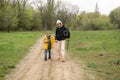 A mother and a young son walk in the park. A woman with a tourist mat and a boy walk about the road in the park, the forest Royalty Free Stock Photo