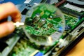 The motherboard is magnified through a magnifying glass. Hardware upgrades computer processor of the service component of the