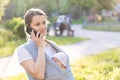 Motherhood, care, infants, summer, communication, parenting concept - Young beautiful mom with a newborn baby in a sling Royalty Free Stock Photo