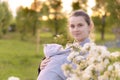 Motherhood, care, infants, summer, parenting concept - Young beautiful mom with a newborn baby in a sling walks and Royalty Free Stock Photo