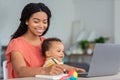 Motherhood And Education. Young Black Woman With Baby On Hands Study Online Royalty Free Stock Photo