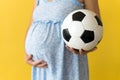 Motherhood, femininity, football, sport, dairy, hot summer. croped unrecognizable pregnant young pretty woman in floral Royalty Free Stock Photo