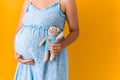 Motherhood, femininity, hot summer - croped portrait pregnant unrecognizable woman in blue dress holds soft toy teddy