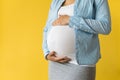 Motherhood, femininity, love, care, waiting, hot summer - bright croped Close-up unrecognizable pregnant woman in shirt Royalty Free Stock Photo