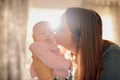 Motherhood is infinite optimism. Shot of a mother kissing her baby girl at home. Royalty Free Stock Photo