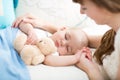 Motherhood. Parenthood. Young mother looking at her baby sleeping in bed Royalty Free Stock Photo