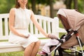 Mother with smartphone, earphones and stroller Royalty Free Stock Photo