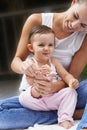 Motherly love. A young mother playing lovingly with her baby toes while they sit outside. Royalty Free Stock Photo