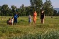 Mothers and children stand and talk in a clearing with wild gophers on a sunny summer day