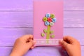 Child holds a flower card in his hands. Child made a greeting card for mom or dad. Birthday, Mothers Day, Fathers Day gift idea Royalty Free Stock Photo