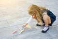 Mothers Day. Child girl draws gift surprise to Mummy - picture of crayons on the asphalt.