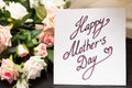 Mothers day handwritten card with rustic roses on wooden board Royalty Free Stock Photo