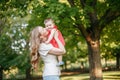 Mothers Day holiday. Young smiling Caucasian mother and girl toddler daughter hugging in park. Mom kissing child baby on summer Royalty Free Stock Photo