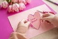 Mothers Day.I love you, Mom.Flowers and cards for mom. Childrens hands holding a heart card.Pink heart card and pink Royalty Free Stock Photo