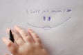 Mothers day. I love you mom inscription on a white sheet and a childs hand with a pen.Holiday of all mothers Royalty Free Stock Photo